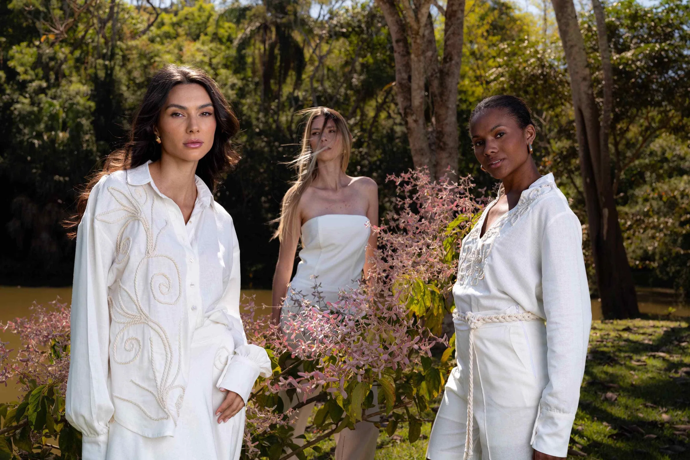 Fashion editorial with three women dressed in white in a garden